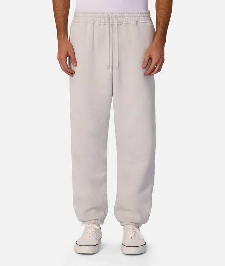 Beige sweatpants worn by a person on a white background