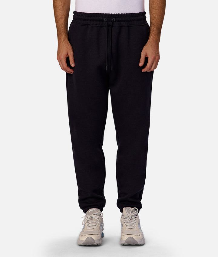 Person wearing black sweatpants on a white background