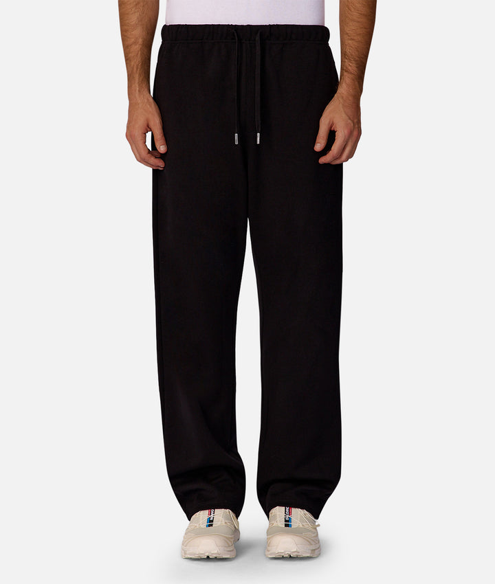 Black sweatpants worn by a person on a white background