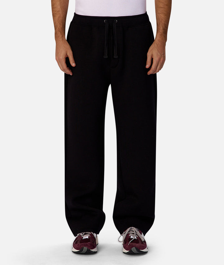 Person wearing black sweatpants on a white background