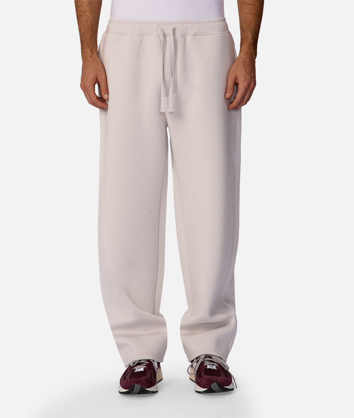 Beige sweatpants worn by a person on a white background