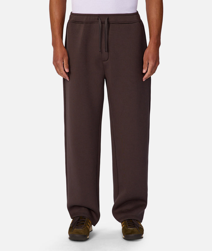 Brown sweatpants worn by a person on a white background
