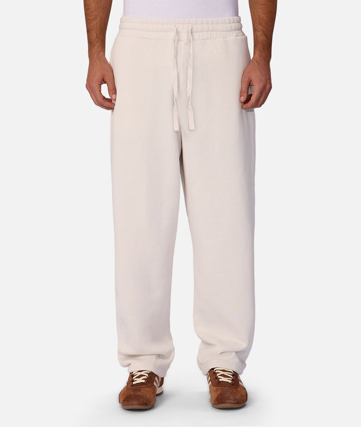 Person wearing cream-colored sweatpants on a white background