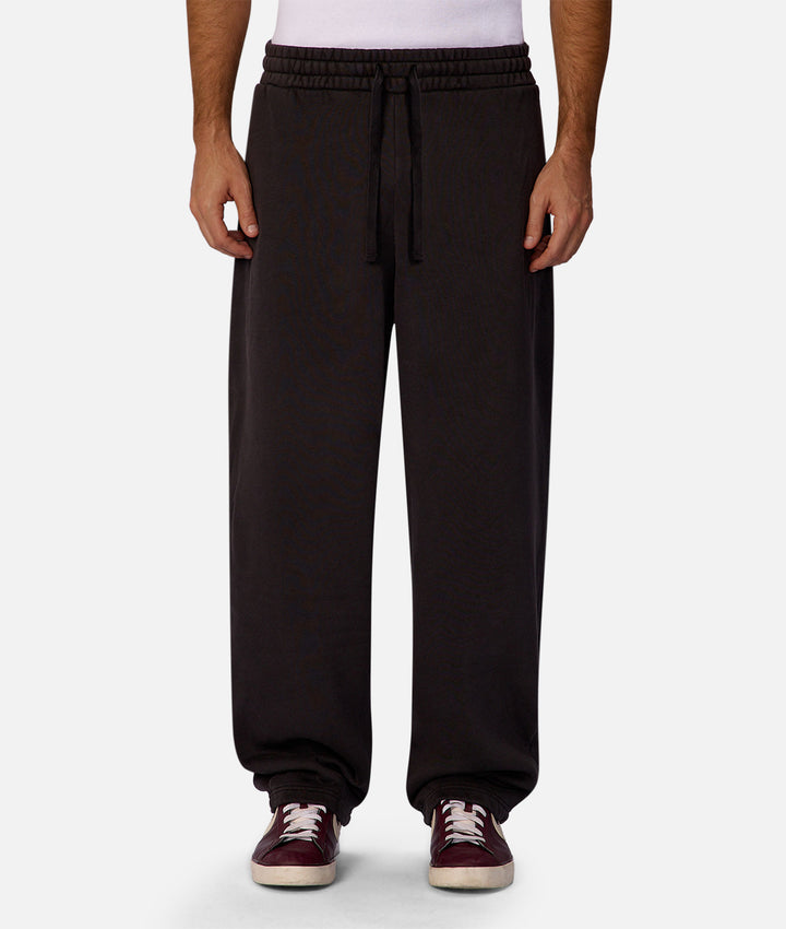 Black sweatpants worn by a person on a white background