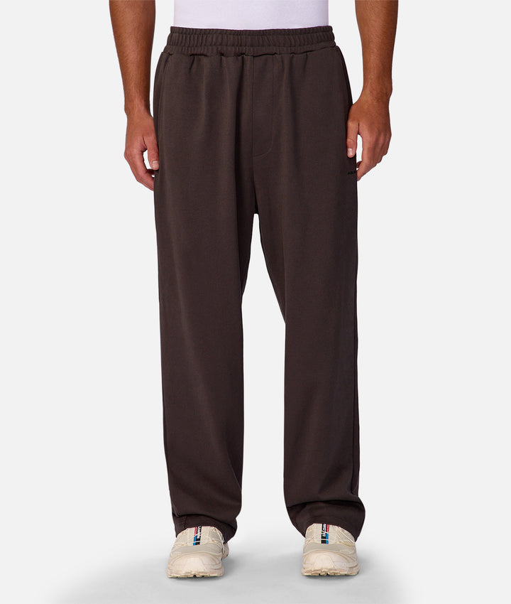 Brown sweatpants worn by a person on a white background