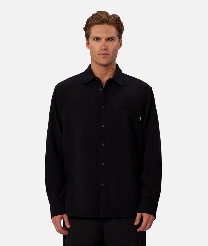 Man wearing a black button-up shirt against a white background