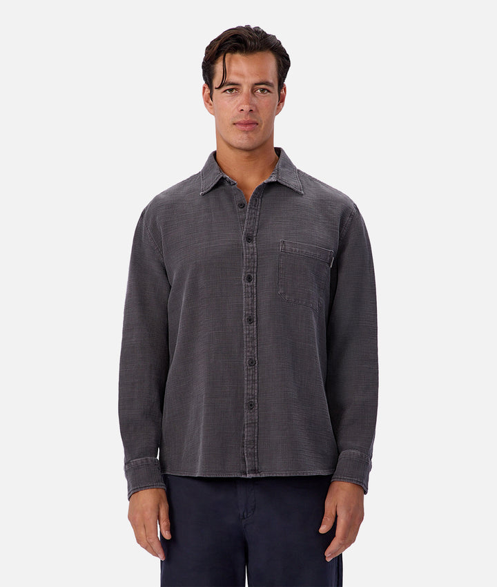 Man wearing a gray button-up shirt on a white background