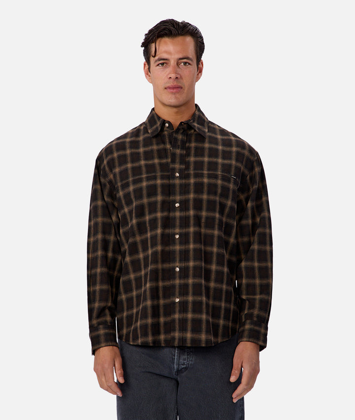 Man wearing a brown plaid shirt on a white background