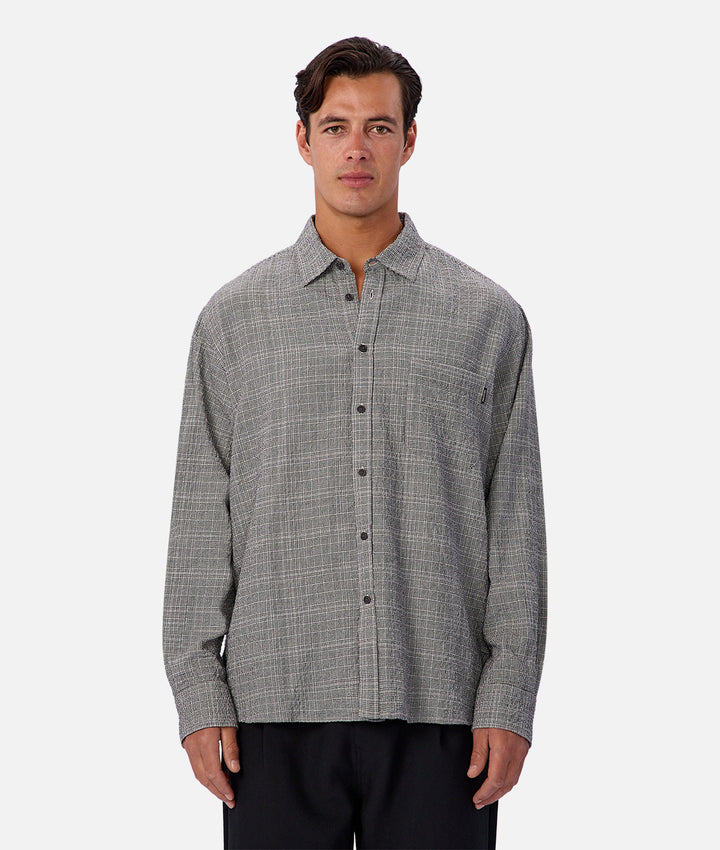 Man wearing a gray checkered shirt on a white background