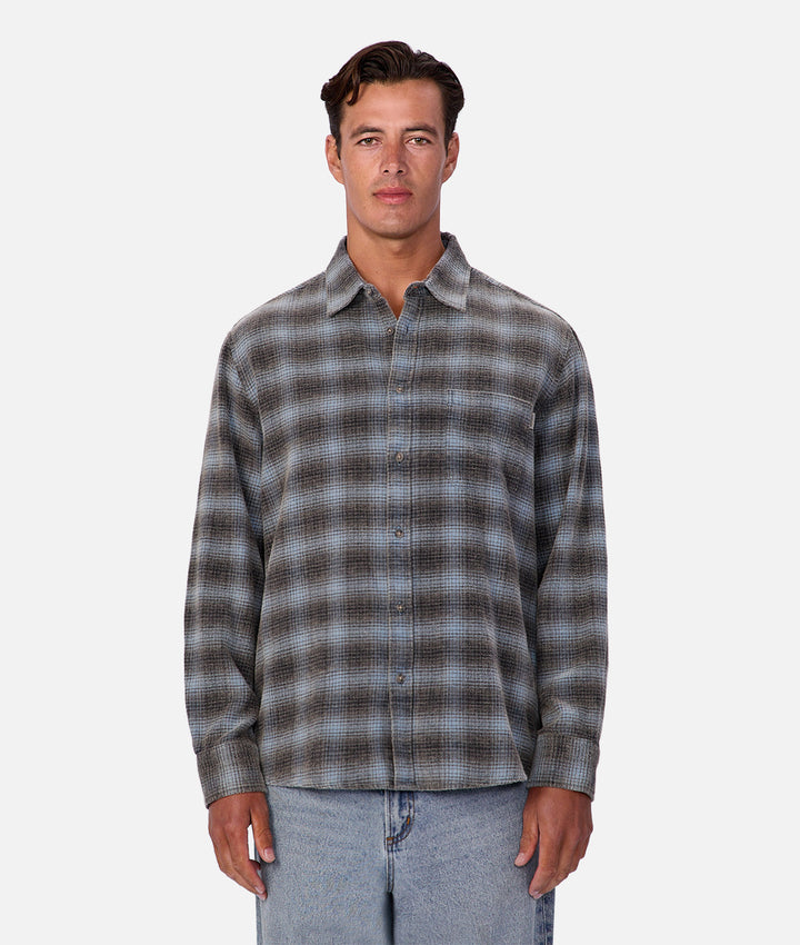 Man wearing a plaid shirt and jeans on a white background