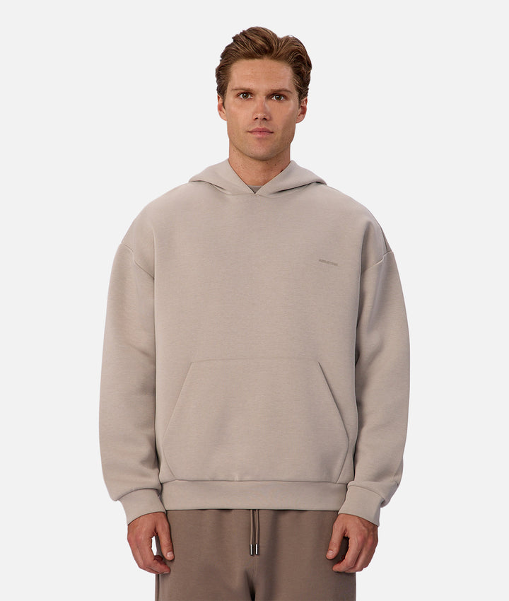 Man wearing a beige hoodie on a white background