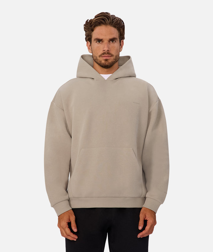Man wearing a beige hoodie on a white background