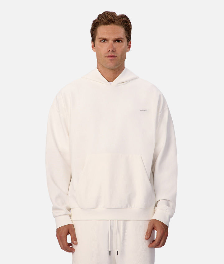 Man wearing a white hoodie and pants on a white background