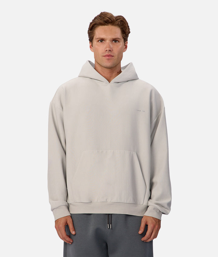 Man wearing a light gray hoodie on a white background