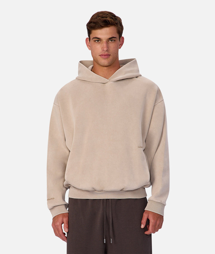 Man wearing a beige hoodie on a white background