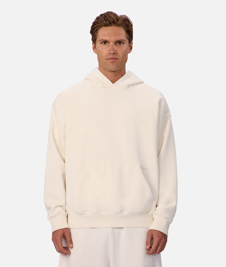 Man wearing a white hoodie on a plain background