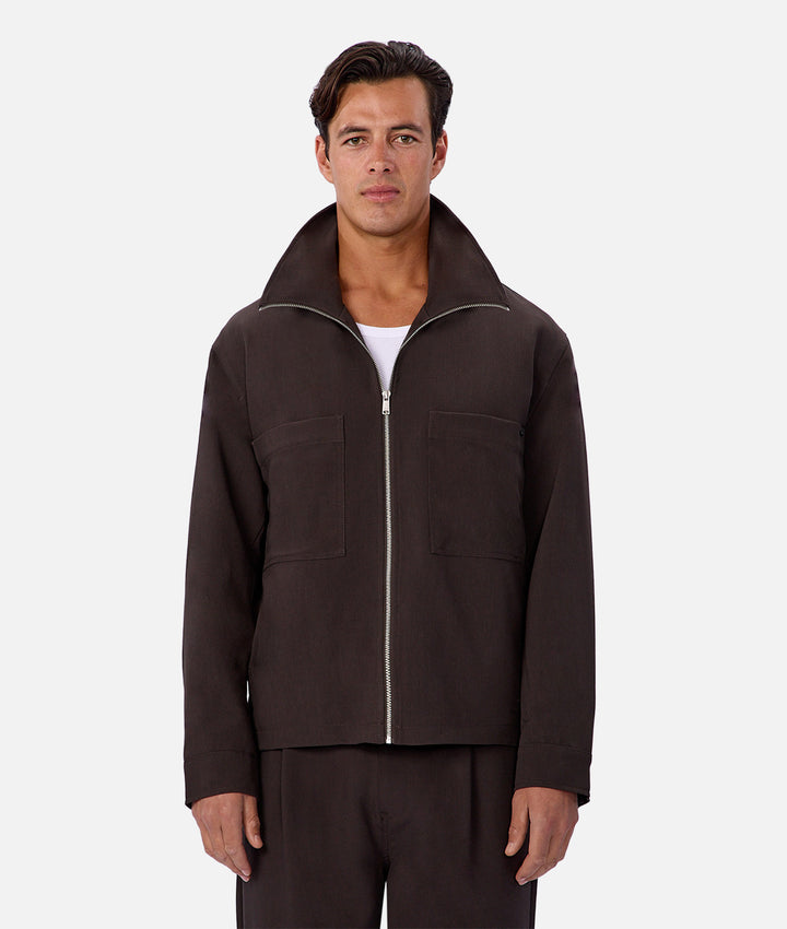 Man wearing a brown jacket and pants on a white background
