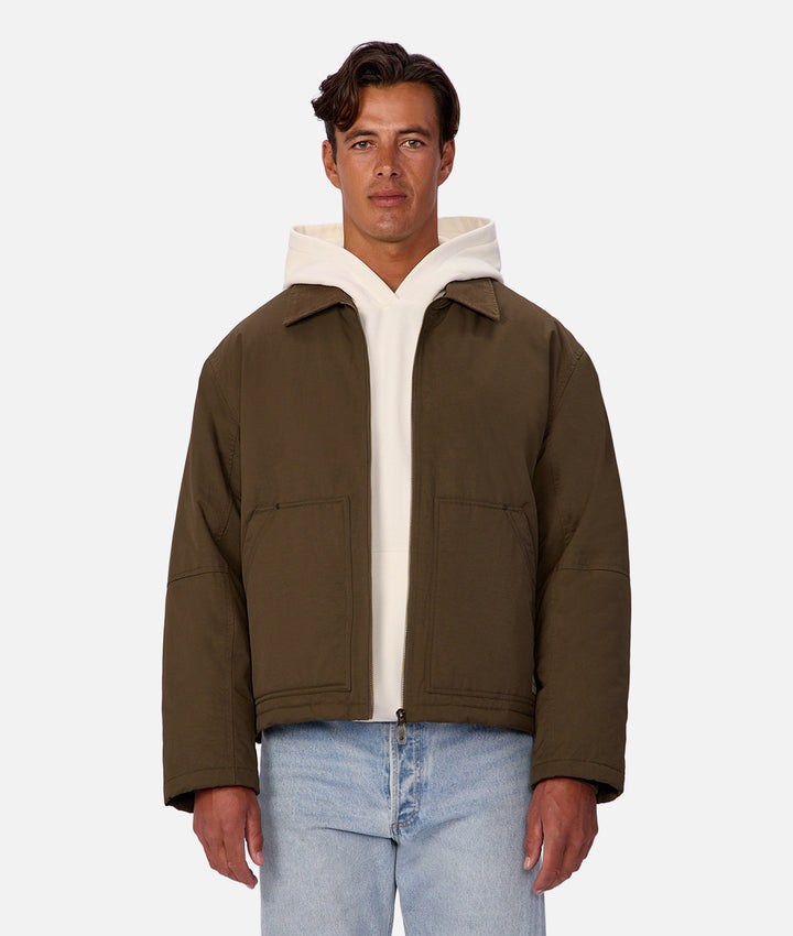 Man wearing a brown jacket with a white inner lining on a white background