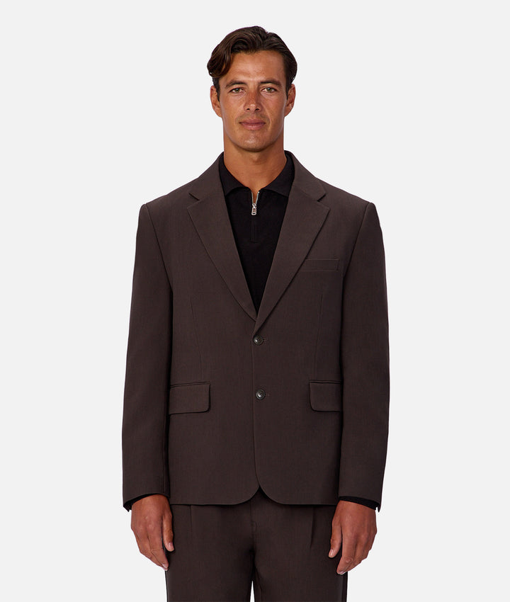 Man wearing a brown suit jacket on a white background