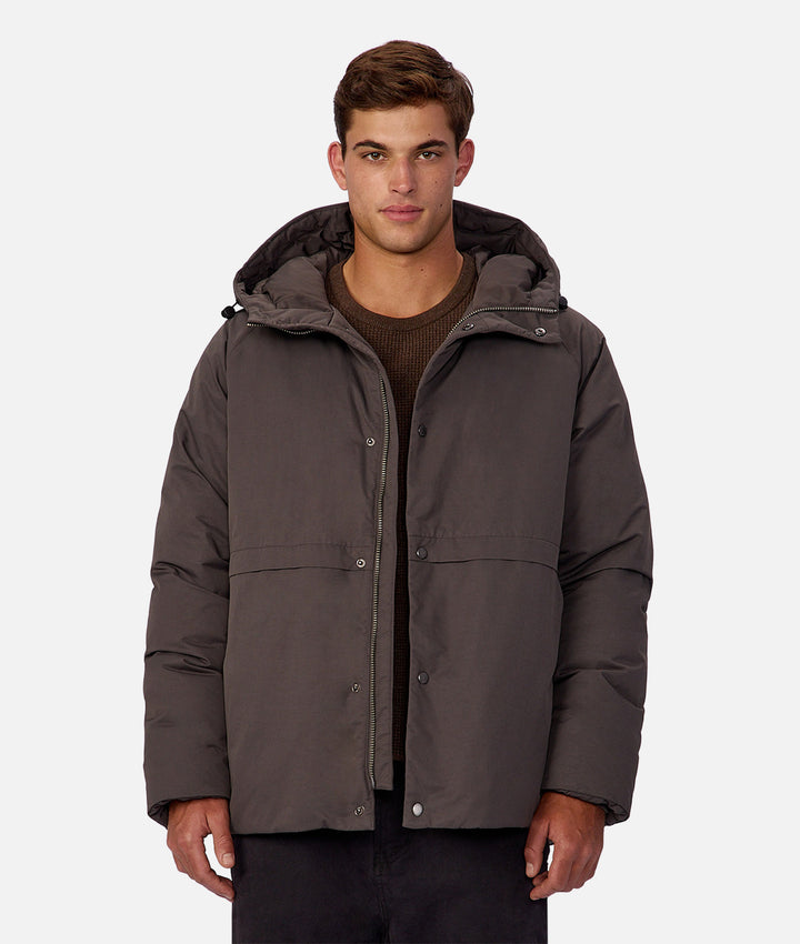 Man wearing a gray jacket with a hood on a white background