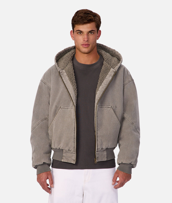 Man wearing a gray jacket with a hood on a white background