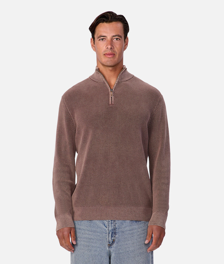 Man wearing a brown sweater with a quarter zip on a white background