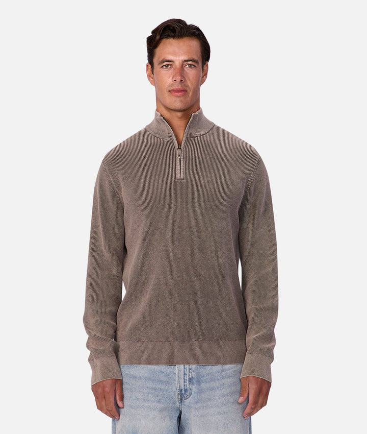 Man wearing a brown quarter-zip sweater on a white background