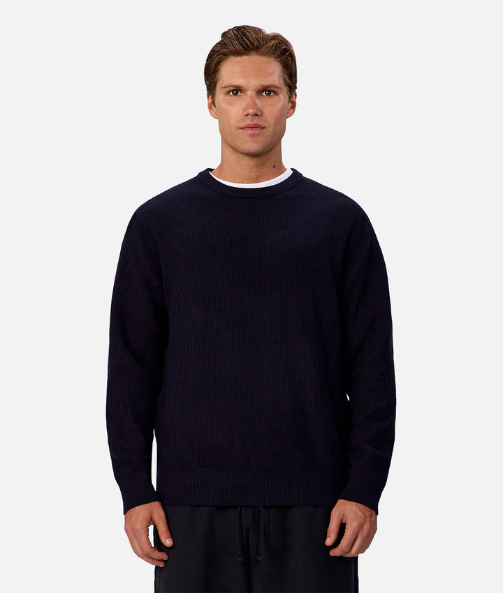Man wearing a navy blue sweater on a white background