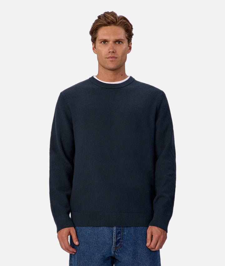 Man wearing a navy blue sweater on a white background