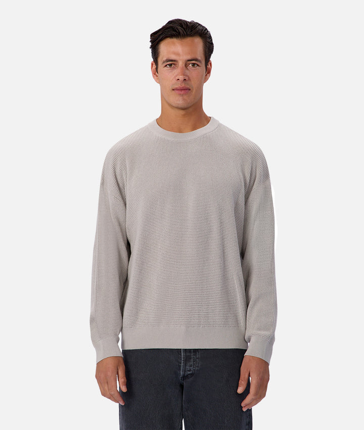 Man wearing a light gray sweater on a white background