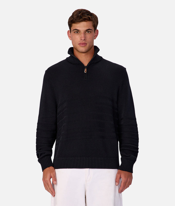 Man wearing a black sweater with a zipper on a white background
