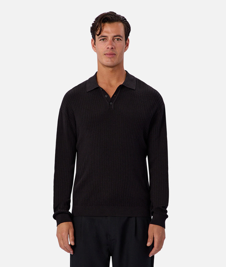 Man wearing a black ribbed sweater on a white background