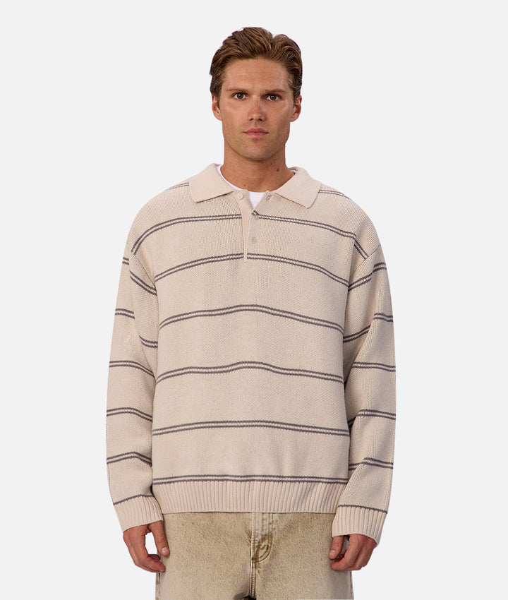 Man wearing a beige and brown striped sweater on a white background