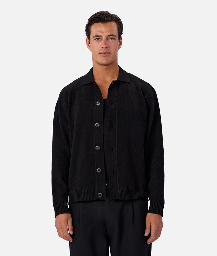 Man wearing a black button-up shirt on a white background