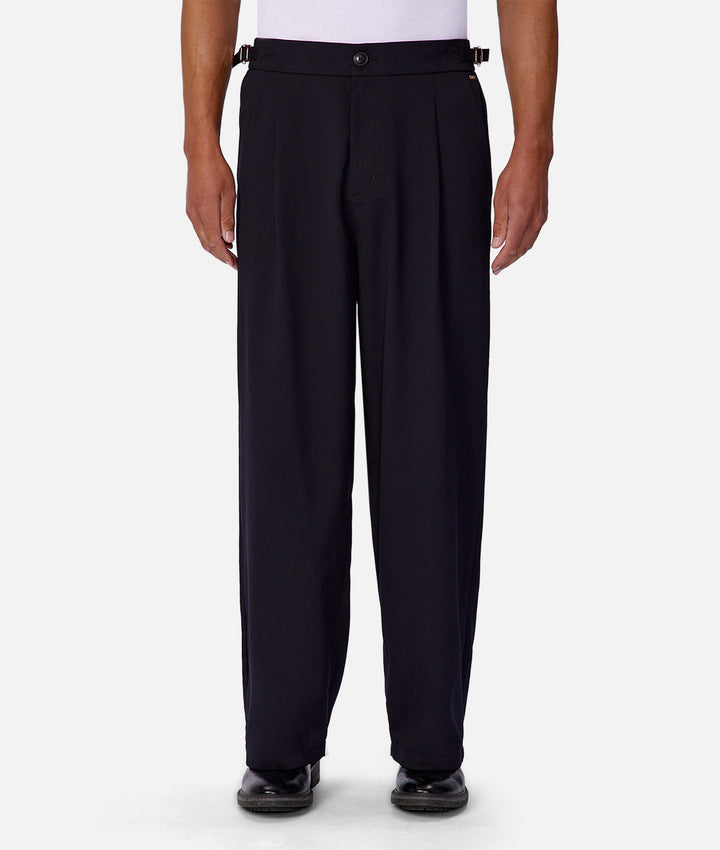 Black pleated pants worn by a person on a white background