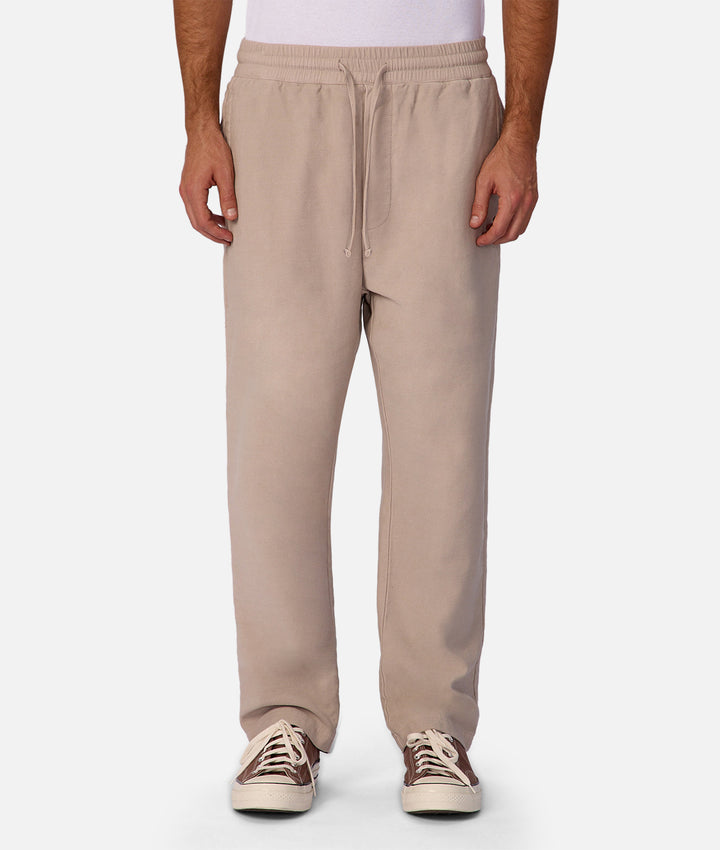 Beige sweatpants worn by a person on a white background
