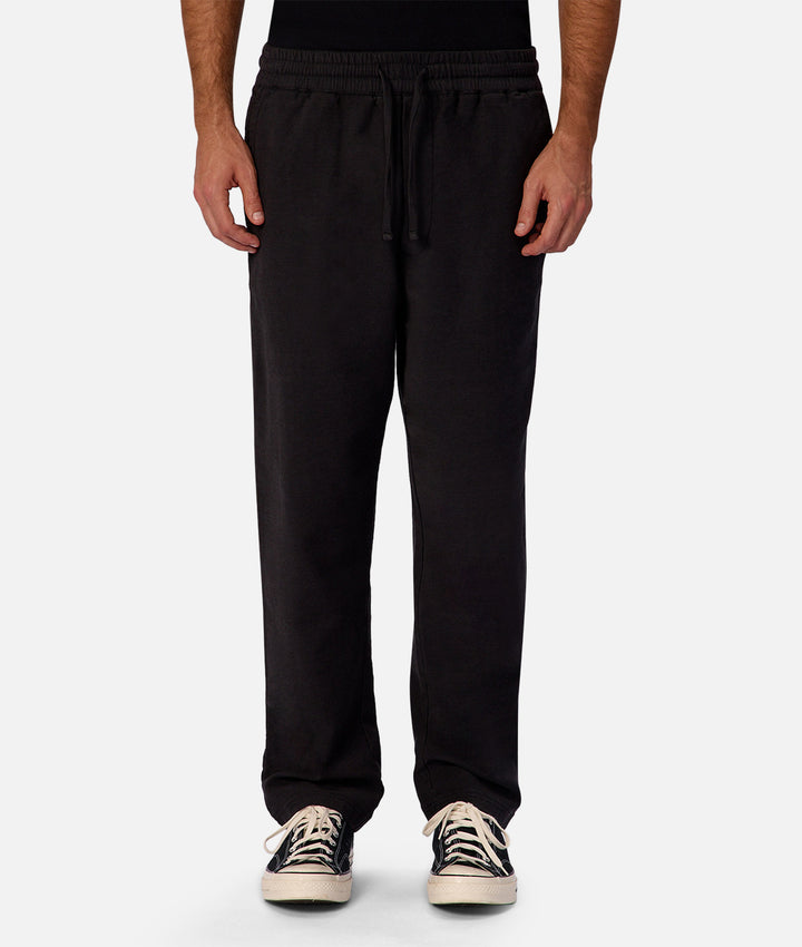 Black sweatpants worn by a person on a white background