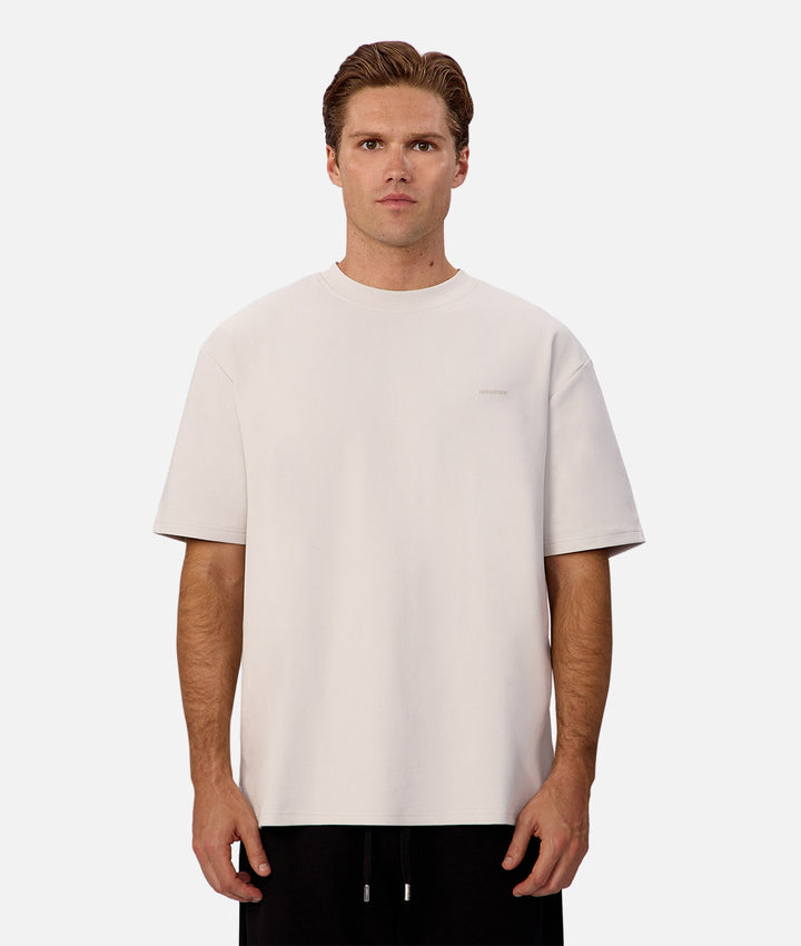 Man wearing a plain white t-shirt on a white background