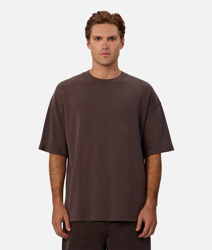 Man wearing a plain brown t-shirt on a white background