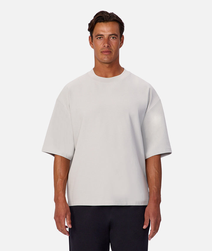 Man wearing a light gray t-shirt on a white background
