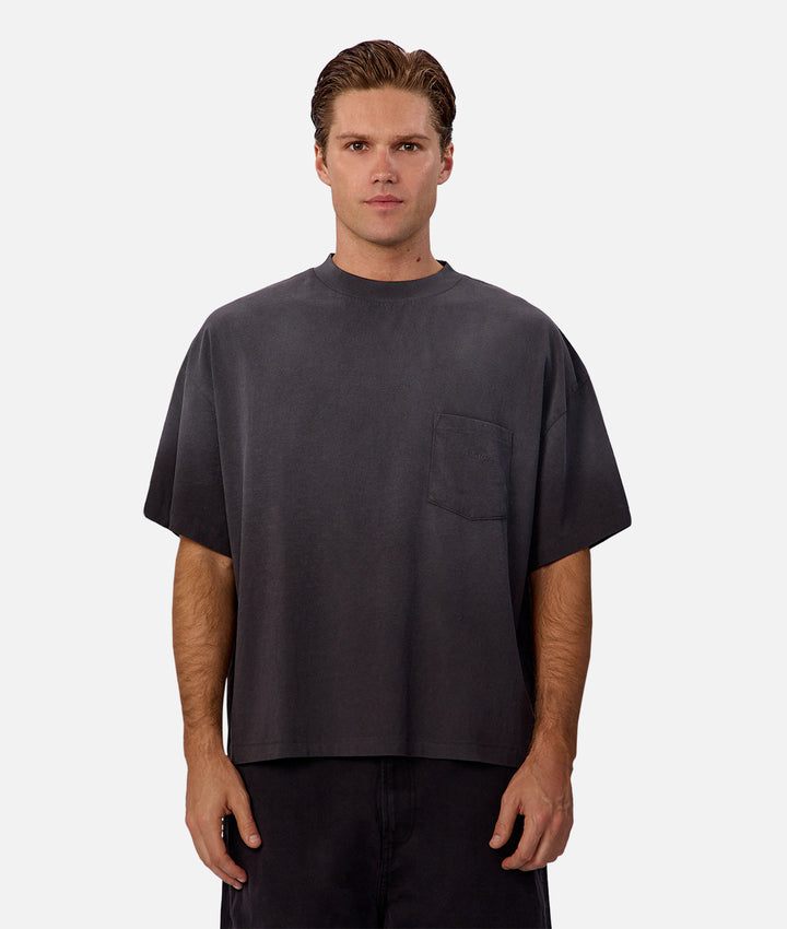 Man wearing a plain dark gray t-shirt on a white background