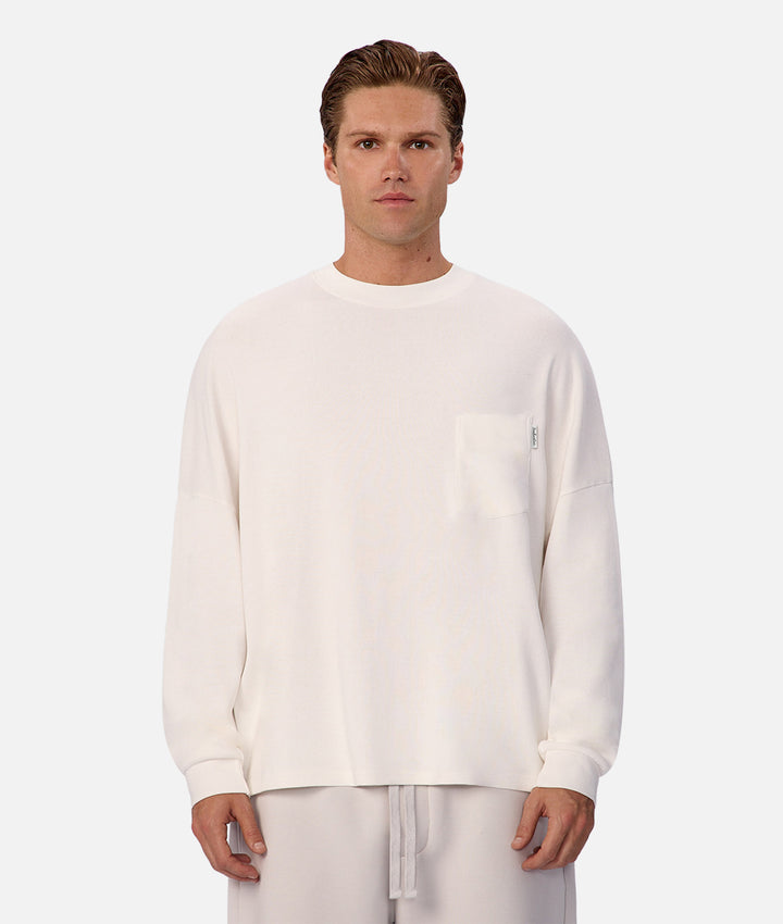Man wearing a white long-sleeve shirt and pants on a white background