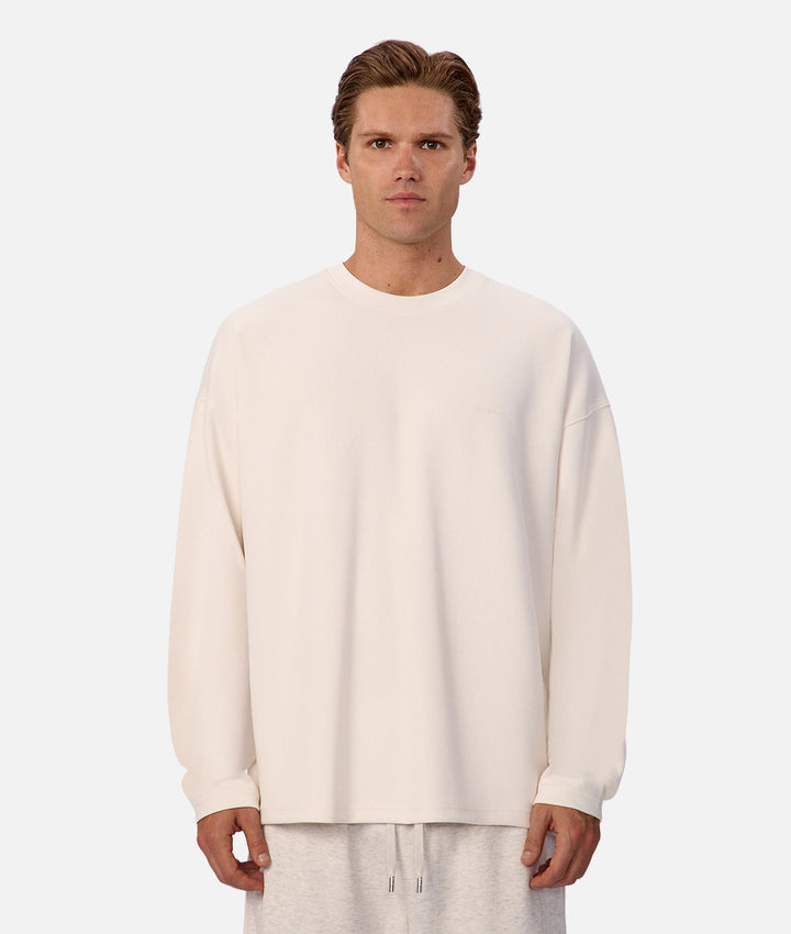 Man wearing a white sweater and pants on a white background