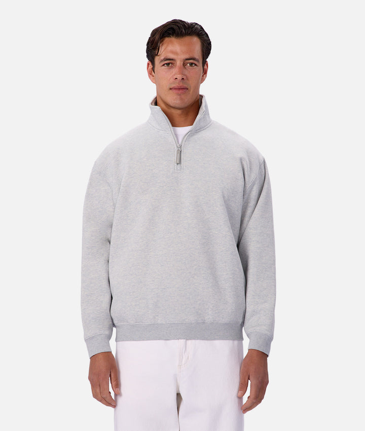 Man wearing a gray quarter-zip sweater on a white background