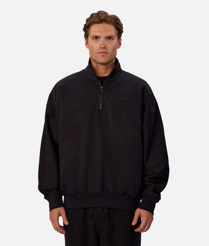 Man wearing a black quarter-zip sweatshirt on a white background