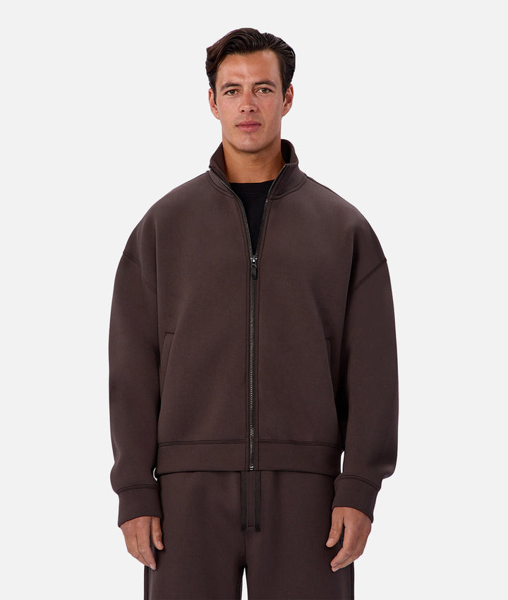 Man wearing a brown tracksuit against a white background