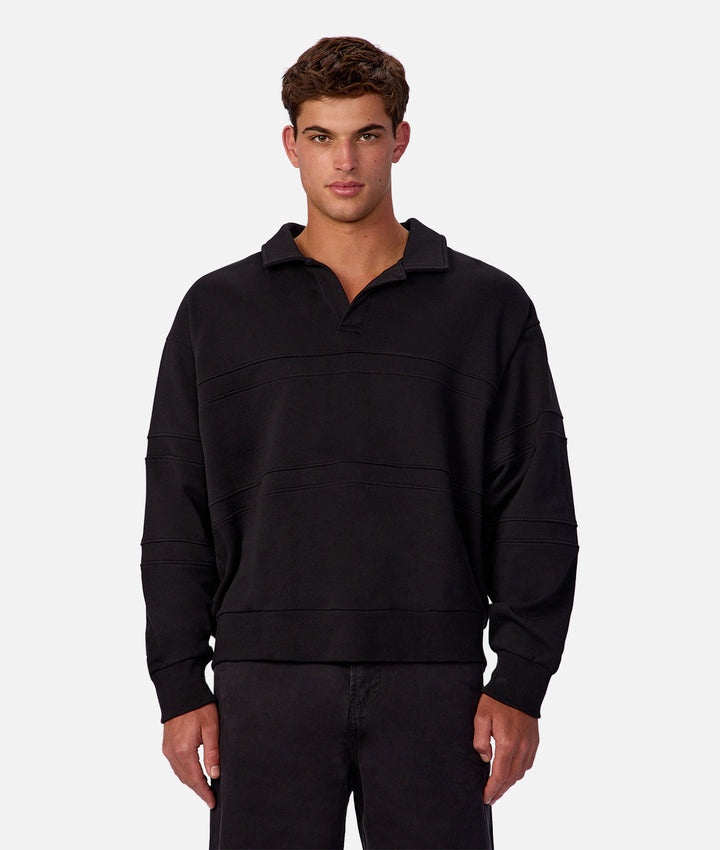 Man wearing a black pullover with a collar on a white background